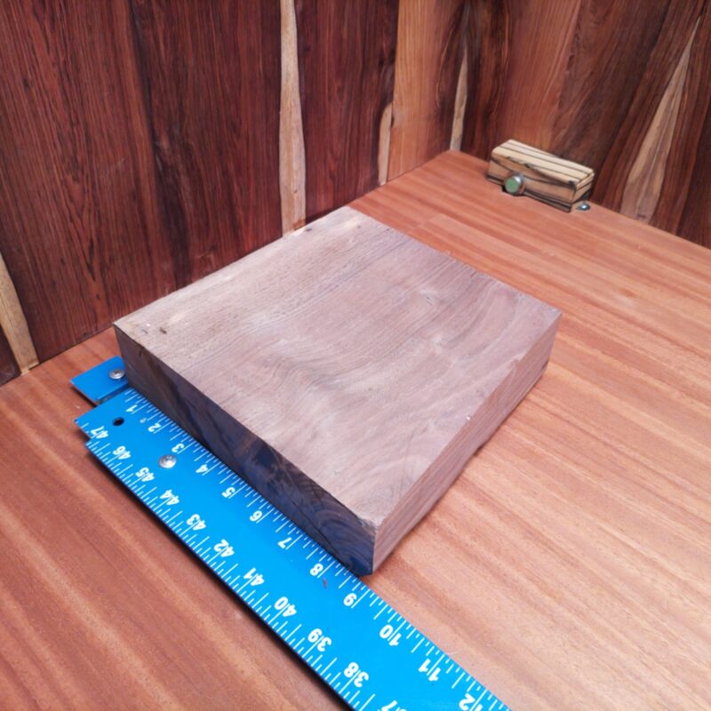 This Claro Walnut is no ordinary wood; it's a transformation machine! Turn it into elegant serving trays, fancy jewelry boxes, or even high-end wine racks for your next dinner party. Why settle for average when you can have custom drawer fronts or a unique wooden chess set? Your guests won't just see wood; they'll see luxury. This piece of Claro Walnut measures 2.4 inches by 8.7 inches by 8.0 inches, offering a high-quality option for a variety of woodworking projects.