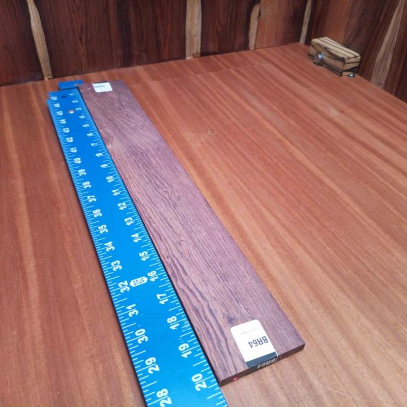 Honduran Rosewood Acoustic Rift Sawn Fingerboard Blank 0.4" X 2.9" X 20.2" - HRAFBR000064 3 Crafted from premium Honduran Rosewood, this fingerboard blank is perfect for luthiers seeking richness in tone. The rift-sawn design enhances stability and visually stunning grain patterns ideal for acoustic instruments. Easy to shape and work with, this blank promises to elevate your next project with a luxurious finish and deep resonance. Step up your craftsmanship with this robust yet elegant wood choice and enjoy a seamless crafting experience! It is a Honduran Rosewood Acoustic Rift Sawn fingerboard blank with dimensions of 20.2 x 2.9 x 0.4 inches.