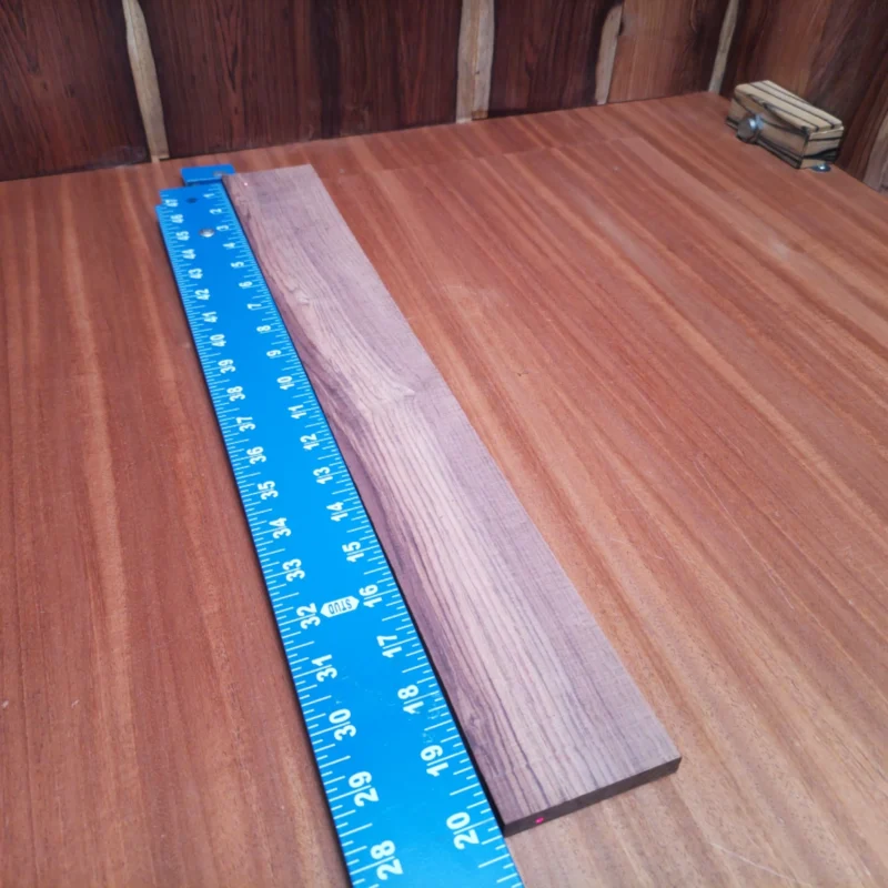 Fingerboard Blanks 86 Crafted from premium Honduran Rosewood, this fingerboard blank offers unparalleled sound quality and durability. Measuring 0.4" x 2.6" x 20.1", it’s designed for luthiers seeking rich tonal depth and striking aesthetics for acoustic instruments. Perfect for enhancing your next build, this blank provides a reliable foundation for high-quality fingerboards. Elevate your craftsmanship with this must-have material—your guitar will thank you! It is a Honduran Rosewood Acoustic Rift Sawn fingerboard blank with dimensions of 20.1 x 2.6 x 0.4 inches.