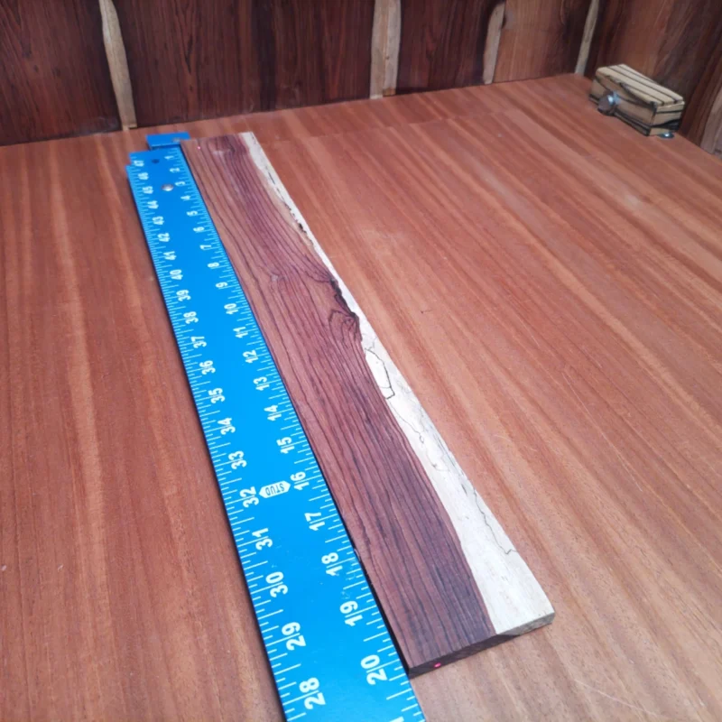 Fingerboard Blanks 79 Unlock your creativity with this Honduran Rosewood Acoustic blank. Perfect for luthiers, its rift-sawn design ensures optimum grain orientation for rich tonal quality. Experience the warm, vibrant sound that resonates beautifully. With its impressive durability and stunning aesthetics, this blank is your toolkit's new best friend! Get ready to craft unforgettable acoustic masterpieces. It is a Honduran Rosewood Acoustic Rift Sawn fingerboard blank with dimensions of 20.2 x 2.5 x 0.4 inches.