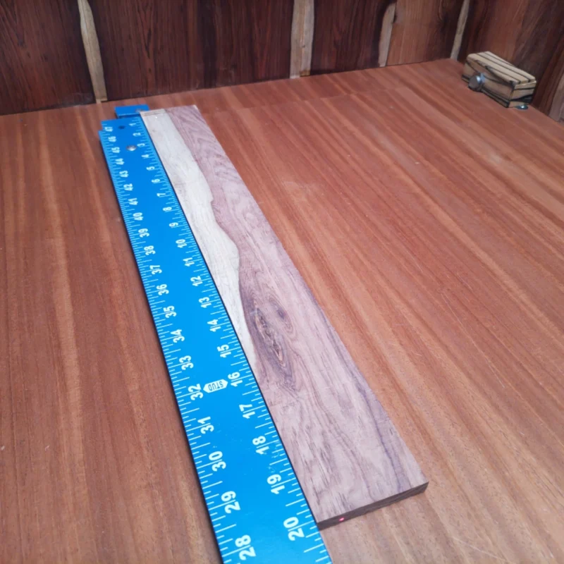 Fingerboard Blanks 88 Discover the allure of Honduran Rosewood for your next acoustic project! This rift sawn fingerboard blank boasts rich tones and resilience, perfect for creating vibrant soundscapes. With its rich, dark grain patterns, this wood is not just a choice, it’s a statement. Elevate your luthiery game with a blank that balances beauty and performance. Get ready to carve your breakthrough instrument with this stunning piece of Mother Nature’s artistry! It is a Honduran Rosewood Acoustic Rift Sawn fingerboard blank with dimensions of 20.1 x 2.6 x 0.4 inches.