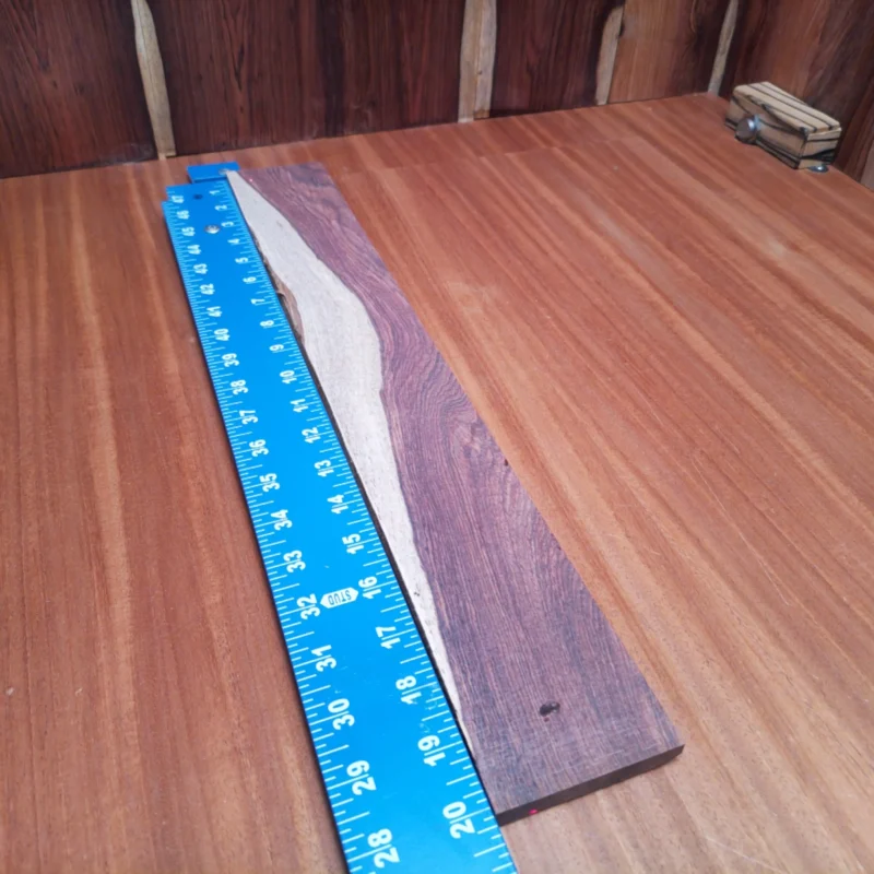 Honduran Rosewood Acoustic Rift Sawn Fingerboard Blank 0.4" X 2.8" X 20.1" - HRAFBR000602 3 This fingerboard blank made from Honduran Rosewood is perfect for your next acoustic project. With its rich color and beautiful grain, it enhances both aesthetics and sound quality. Designed for luthiers, this rift sawn wood offers superior stability and resonance, making it a great addition to any instrument. Craft with confidence and elevate your guitar's performance with this excellent choice for fingerboards. It is a Honduran Rosewood Acoustic Rift Sawn fingerboard blank with dimensions of 20.1 x 2.8 x 0.4 inches.
