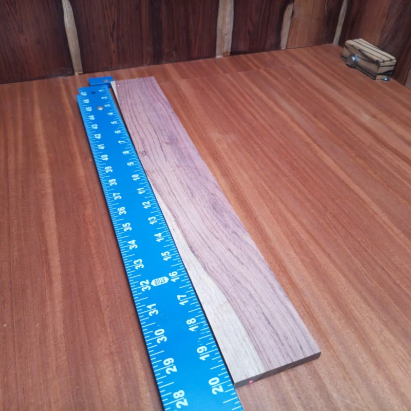 Elevate your builds with this Honduran Rosewood Acoustic blank, offering stunning tonal qualities and gorgeous grain. Perfect for luthiers seeking beauty and resonance, this blank ensures that your instruments stand out. With a size that’s ideal for various acoustic designs, you’ll appreciate the combination of functionality and aesthetics. Get ready to create your next masterpiece with this premium fingerboards blank, delivering both lush sound and visual appeal for your projects. It is a Honduran Rosewood Acoustic Rift Sawn fingerboard blank with dimensions of 20.1 x 2.7 x 0.4 inches.