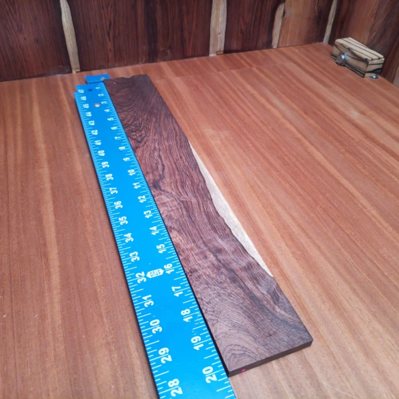 Honduran Rosewood Acoustic Rift Sawn Fingerboard Blank 0.4" X 2.9" X 20.1" - HRAFBR000647 3 Crafted from premium Honduran rosewood, this acoustic fingerboard blank is perfect for luthiers. Its rift sawn cut enhances stability, allowing for smooth playability without compromising tone quality. Whether you’re crafting a new guitar or repairing an old classic, this fingerboard brings both beauty and functionality to your projects. Say goodbye to fingerboard woes and hello to crisp, vibrant sound with every strum! It is a Honduran Rosewood Acoustic Rift Sawn fingerboard blank with dimensions of 20.1 x 2.9 x 0.4 inches.