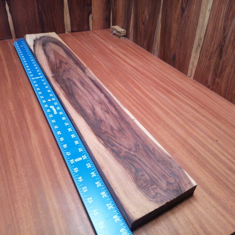 With Honduran Rosewood G1, your decorative wall art will truly shine like the sun! Picture this: a unique charcuterie board that’s so beautiful even the cheese feels honored. Or how about a luxurious guitar neck that makes every strum sound like a dream? Finish it off with a stylish key holder, and you’ve got a modern home that sings! This piece of Honduran Rosewood measures 1.1 inches by 5.6 inches by 39.0 inches, offering a high-quality option for a variety of woodworking projects.